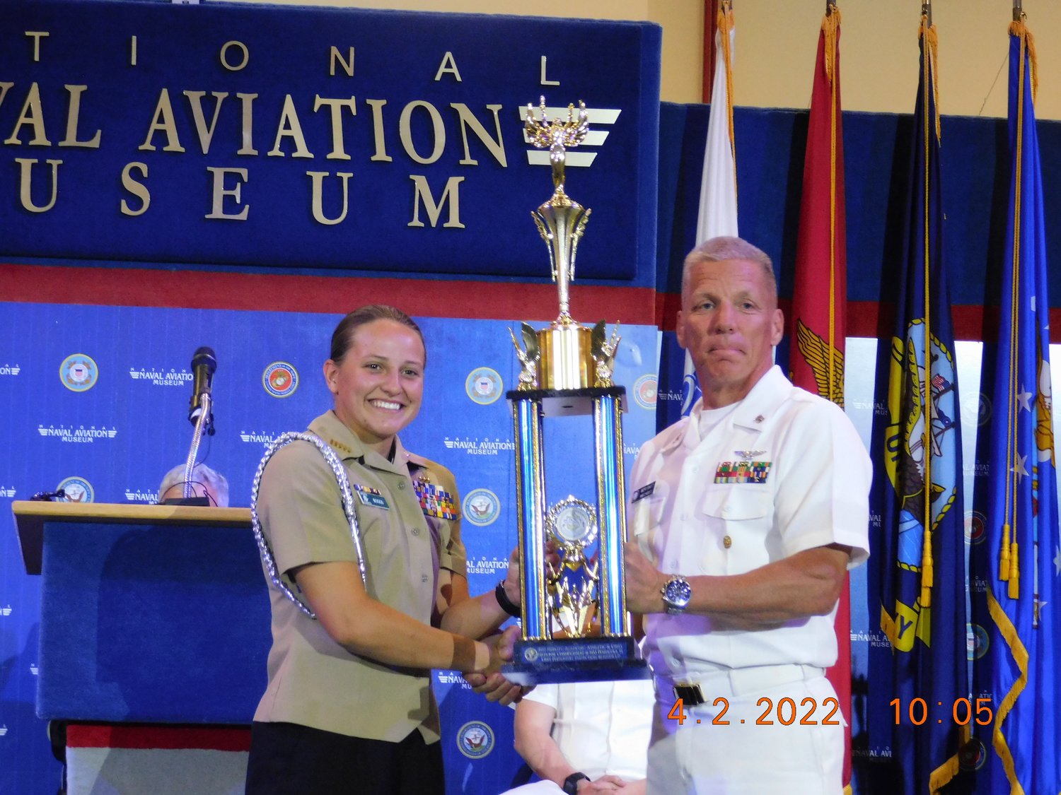 Battalion Commander Kaitlyn Boggs receives the first place overall unarmed basic trophy at the Navy National Academic, Athletic and Drill Championships.