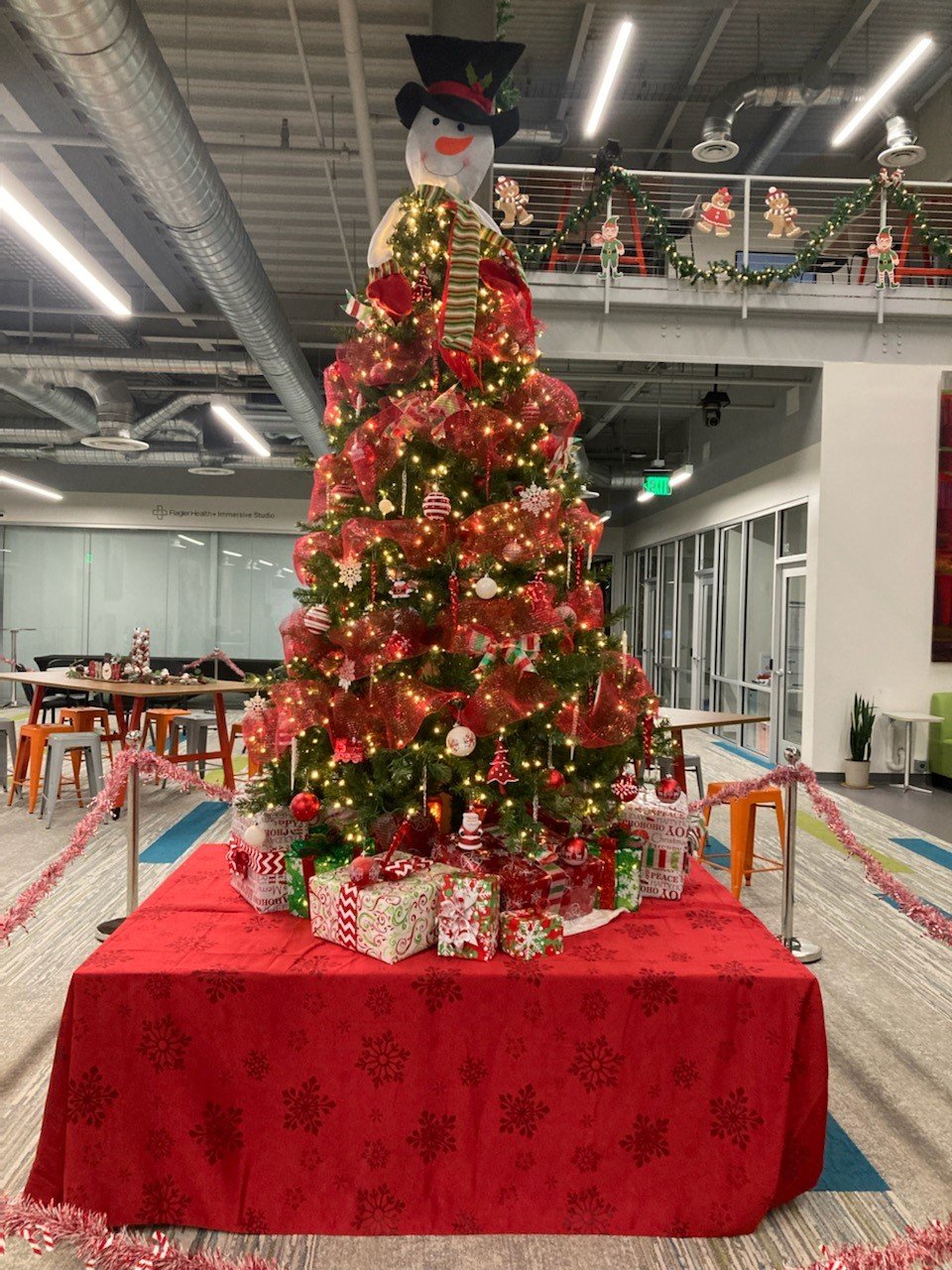 A festive Christmas tree stands tall in the main gathering area at the link.