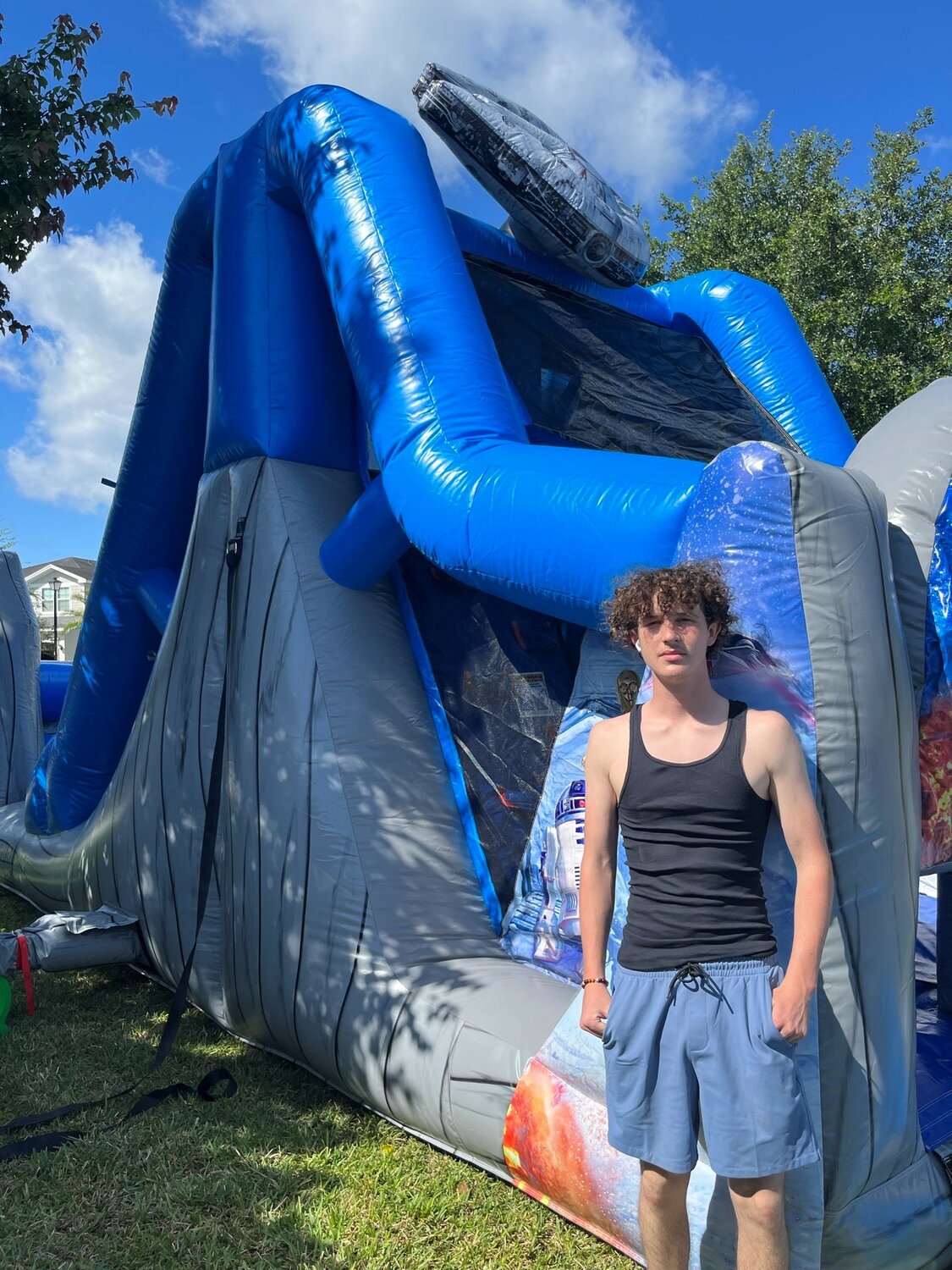 Rogan Drainer stands next to “Star Wars” themed obstacle course, one of the “bounce houses” rented by Stars N Stripes Inflatables.